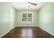 Bedroom featuring hardwood floors, window views, and a ceiling fan at 1663 Pounds Sw Rd, Stone Mountain, GA 30087