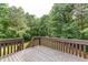 Open wooden deck overlooking a serene wooded backyard with green trees and natural landscaping at 408 Gray Fox Dr, Canton, GA 30114