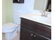 Cozy bathroom featuring a vanity with a white countertop, toilet, and dark brown wood cabinets at 6570 Canyon Cv, Cumming, GA 30028