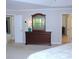 Well-lit bedroom featuring dresser with mirror and multiple doors leading to other rooms at 6570 Canyon Cv, Cumming, GA 30028