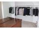 Organized closet with clothes, with an antique wooden chest in front of the hanging clothes at 6570 Canyon Cv, Cumming, GA 30028