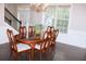 Elegant dining room with hardwood floors, traditional table, and bright window, perfect for formal gatherings at 6570 Canyon Cv, Cumming, GA 30028
