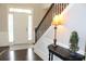 Welcoming entryway with hardwood floors, staircase, and decorative table lamp, creating a warm ambiance at 6570 Canyon Cv, Cumming, GA 30028