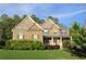 Inviting two-story brick home with a manicured lawn and charming front porch perfect for relaxing at 6570 Canyon Cv, Cumming, GA 30028