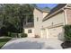 Exterior view of a two-car garage with a concrete driveway and well-maintained landscaping at 6570 Canyon Cv, Cumming, GA 30028
