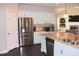 Bright kitchen with stainless steel refrigerator, island with sink, granite countertops, and white cabinets at 6570 Canyon Cv, Cumming, GA 30028