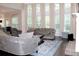 Elegant living room featuring a fireplace, stylish sofas, hardwood floors, and large windows at 6570 Canyon Cv, Cumming, GA 30028