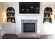 Cozy living room featuring a brick fireplace, a TV, and built-in bookshelves at 6570 Canyon Cv, Cumming, GA 30028