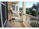 Inviting covered porch with stone accents and white railings, offering a relaxing outdoor space at 6570 Canyon Cv, Cumming, GA 30028