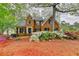 Charming two-story brick home featuring a well-manicured front yard with colorful azaleas and mature trees at 134 Waterloch Ct, Lawrenceville, GA 30043