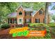 Two-story brick home featuring black shutters, landscaped front yard, and a welcoming front porch at 134 Waterloch Ct, Lawrenceville, GA 30043