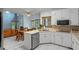 Bright kitchen featuring white cabinets, stainless steel appliances and a view of a breakfast nook and living room at 134 Waterloch Ct, Lawrenceville, GA 30043