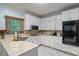 A white kitchen featuring matching white cabinetry and marbled floors with stainless steel appliances and natural light at 134 Waterloch Ct, Lawrenceville, GA 30043
