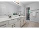 Bathroom with double sinks, white vanity with brushed chrome hardware, and a walk-in shower at 1772 Benningfield Sw Dr, Marietta, GA 30064