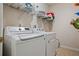 Practical laundry room featuring modern washer and dryer appliances and built-in shelving for organized storage at 1772 Benningfield Sw Dr, Marietta, GA 30064