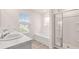 Bright bathroom features double sinks, soaking tub and glass-enclosed shower at 1940 Van Allen Ct, Dacula, GA 30019