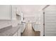 Open kitchen with white cabinets, stainless appliances, granite countertops, and hardwood floors at 1940 Van Allen Ct, Dacula, GA 30019