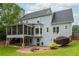 A beautiful backyard featuring a screened-in porch, stone patio, and lovely landscaping at 6610 Major Dr, Cumming, GA 30040