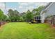 Expansive backyard with lush green grass, mature trees, and space for outdoor activities at 6610 Major Dr, Cumming, GA 30040
