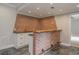 Wet bar with brick accent wall, white cabinets, and a live edge bar top at 6610 Major Dr, Cumming, GA 30040