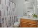 Bathroom featuring a tiled shower curtain, a window, and a vanity with storage at 6610 Major Dr, Cumming, GA 30040