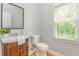 Well-lit half bathroom with a window, vanity and a hardwood floor at 6610 Major Dr, Cumming, GA 30040