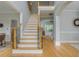 Bright and airy foyer with hardwood floors, staircase, and views into other rooms at 6610 Major Dr, Cumming, GA 30040