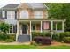 Inviting covered front porch with white columns and railing detail, plus manicured landscaping at 6610 Major Dr, Cumming, GA 30040