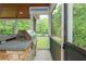An outdoor kitchen on the screened-in porch with stone accents and a built-in stainless grill at 6610 Major Dr, Cumming, GA 30040