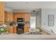Open kitchen with wooden cabinetry, stainless appliances, and tiled backsplash at 6610 Major Dr, Cumming, GA 30040