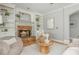Cozy living room featuring a stone fireplace with built-in bookshelves and hardwood flooring at 6610 Major Dr, Cumming, GA 30040