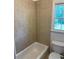 Bathroom with neutral tiled shower/tub combination and window at 753 Hayes Ct, Atlanta, GA 30349
