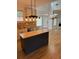 Eat-in kitchen features a kitchen island with light fixture and seamless transition to the living room at 753 Hayes Ct, Atlanta, GA 30349
