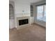 Carpeted living room featuring a cozy fireplace with built-in shelving at 753 Hayes Ct, Atlanta, GA 30349