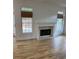Living room featuring hardwood floors, fireplace, and bright windows with stylish woven blinds at 753 Hayes Ct, Atlanta, GA 30349