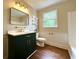Bathroom with a modern vanity, bright lighting and a large window. Bathtub is visible at 942 Batesville Rd, Canton, GA 30115