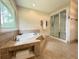 Bathroom featuring a large tub, tiled floors, and a glass shower enclosure at 942 Batesville Rd, Canton, GA 30115