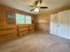 Neutral bedroom featuring a ceiling fan, large window, and closet with sliding doors at 942 Batesville Rd, Canton, GA 30115