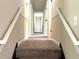 Hallway featuring neutral walls, carpeted stairs, and white rails at 942 Batesville Rd, Canton, GA 30115