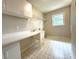 Functional laundry room with white cabinets, countertop, sink, and window at 942 Batesville Rd, Canton, GA 30115