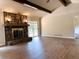 Open-concept living room with a stone fireplace, wood beam ceiling, and hardwood flooring at 942 Batesville Rd, Canton, GA 30115