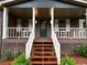Inviting front porch with white railings and wooden stairs, a perfect spot for relaxation at 942 Batesville Rd, Canton, GA 30115