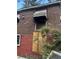 Image shows brick siding, a boarded window, and surrounding shrubbery at 2625 Baker Nw Rd, Atlanta, GA 30318