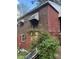 Home exterior featuring brick and siding detail with shrubbery and an open window at 2625 Baker Nw Rd, Atlanta, GA 30318