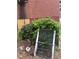 Property with overgrown yard; debris, chair, and broken window leaning against bushes at 2625 Baker Nw Rd, Atlanta, GA 30318