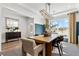 Bright dining room showcases a modern chandelier, stylish decor, and a view of the outdoors through large windows at 5350 Hyde Rd, Cumming, GA 30040