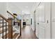 Bright hallway with hardwood floors, open staircase, and views into office and entry, creating an inviting transition space at 5350 Hyde Rd, Cumming, GA 30040