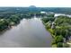 Expansive aerial view of a picturesque lake surrounded by lush greenery and elegant waterfront properties at 7435 Woodruff Way, Stone Mountain, GA 30087