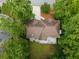 Aerial view of a house with a large backyard and a deck with patio furniture surrounded by lush greenery at 7435 Woodruff Way, Stone Mountain, GA 30087