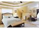 This primary bedroom features a tray ceiling, ceiling fan, and neutral walls with hardwood floors at 7435 Woodruff Way, Stone Mountain, GA 30087